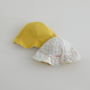 Détail d'un chapeau de soleil réversible en coton avec tissu jaune et motif floral
