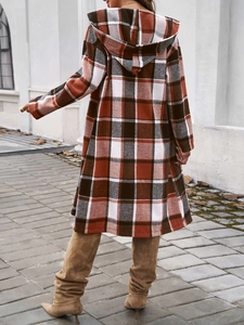 Outdoor street view of a women's long-length color-block plaid hooded coat from the back