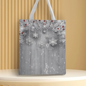 Detail of Christmas canvas tote bag featuring red berries and snowflakes on a white pedestal