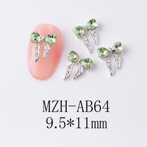 Vue macro de breloques à ongles en forme de nœud avec cœurs verts et cadres argentés