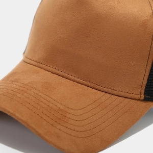Detailed macro view of caramel suede baseball cap showing reinforced stitching on the brim