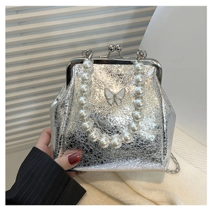 Close-up of silver cracked texture handbag with pearl handle and white butterfly charm