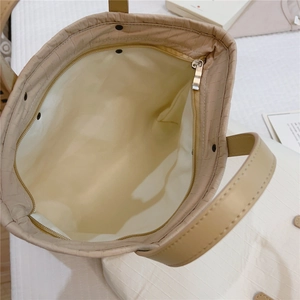 Close-up of beige stripe cotton tote interior featuring a metal zipper inner pocket