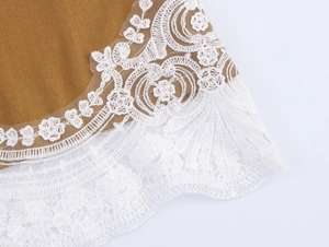 Close-up of brown fabric with delicate white lace trim and refined stitching details