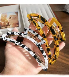 Detail of tortoiseshell and black white spotted large hair claws with metal spring