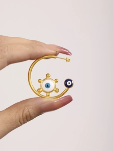 Detailed close-up of C-shaped 18K gold-plated earring with blue enamel evil eye charm