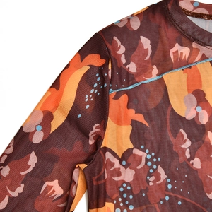 Détail de robe en tulle fleuri marron avec des coutures contrastées bleues sur l'épaule