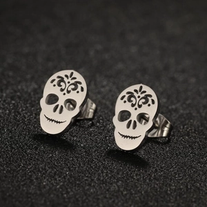 Macro view of retro punk skull stud earrings in polished stainless steel