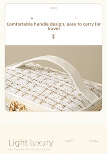 Detailed view of the cream tweed cosmetic bag with gold zippers and a leather handle