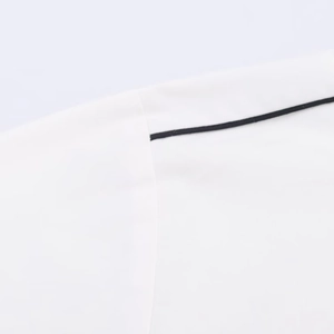 Close-up of contrast black piping on a white poplin shirt with neat stitching detail