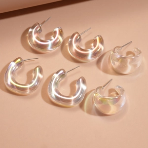 Detailed macro view of iridescent acrylic C-shape hoop earrings with silver pins