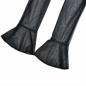 Detailed close-up of sparkly black mesh flared trousers with elegant sheer texture