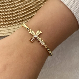 Detail of 18K gold-plated woven bracelet with micro-paved cubic zirconia cross charm