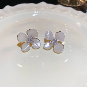 Detail view of pearl flower stud earrings with zircon inlay on a white ceramic tray