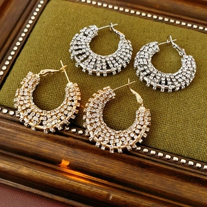 Detail of silver and gold hollow circular earrings with crystal rhinestones inlay