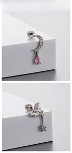 Detailed macro view of silver titanium steel earrings with pink zircon stone pendants
