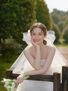 Close-up of oversized sheer tulle bow veil and strapless vintage bridal gown accessory
