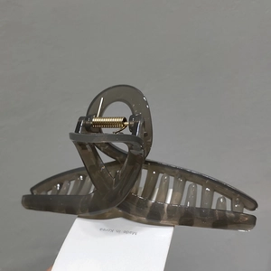 Detail of translucent smoke grey hair claw clip showing a durable gold metal spring