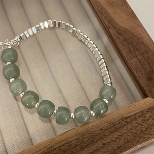 Detail of beaded bracelet with turquoise stones and silver beads on a velvet tray