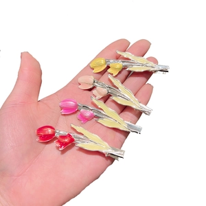 Four colorful tulip enamel hair clips in yellow, pink and red with gold metal stems