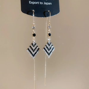 Détails de boucles d'oreilles pendantes élégantes avec pendentif en losange serti de diamants