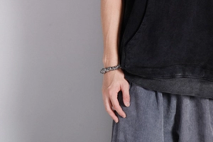 Close-up of a vintage skull chain bracelet made of silver steel on a male wrist