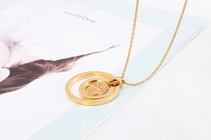 Macro detail of golden Hamsa Hand pendant with dual concentric rings on a thin chain