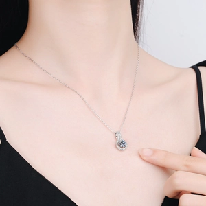 Elegant 2 carat round moissanite pendant necklace with halo stones on a female model