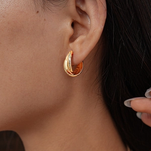 Close-up of elegant gold triple intertwined circle clip-on earrings on a model