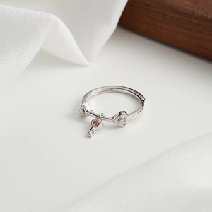 Primo piano di un anello a cuore in argento S925 con ciondolo a chiave e zirconi brillanti