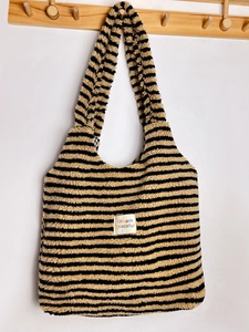 Detailed view of a striped plush lamb velvet tote bag hanging on a wooden hook rack