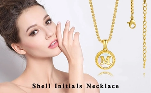 Détail d'un collier plaqué or 18K avec pendentif en nacre blanche et lettre M en métal