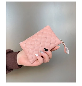 Detalle del monedero de cuero PU rosa acolchado con cremallera dorada en la mano