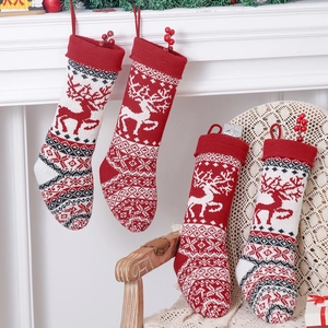 Set of four red knitted Christmas stockings with reindeer patterns and snowflakes