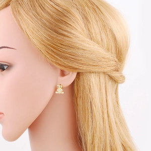 Detailed view of a gold teddy bear stud earring with sparkling zircons on a model