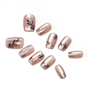 Champagne gold cat eye press on nails with black leaf patterns and foil glitter accents