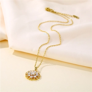 Elegant gold-plated snowflake pendant necklace with sparkling cubic zirconia on soft fabric