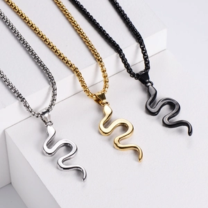 Three cobra snake pendants in gold, silver, and black on modern geometric stairs
