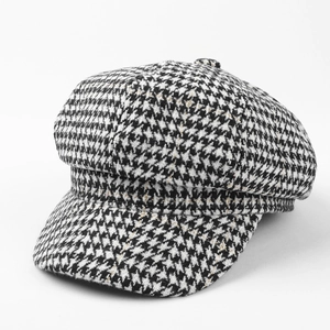 Close-up of houndstooth newsboy cap with subtle gold metallic threads and retro texture