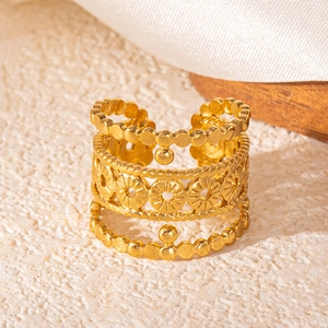 Detailed macro of gold-plated wide bohemian ring with floral cutouts and beaded edges