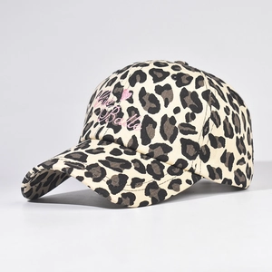 Close-up of leopard print baseball cap with C'est Belle pink embroidery and heart logo