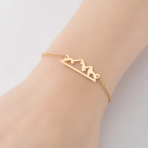 Golden stainless steel bracelet with hollow mountain peak charm on a woman's wrist