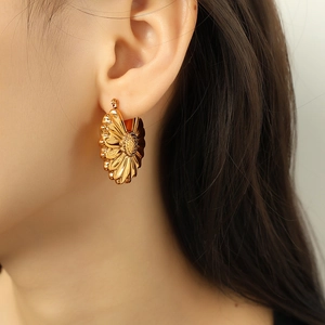 Chic 18K gold plated titanium steel sunflower petal hoop earrings for women worn by model