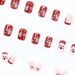 Christmas press-on nails featuring red Santa Claus, elk, and bow designs on white background