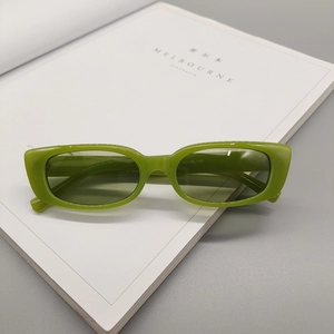 Detail view of translucent green square sunglasses with sizing info on temples