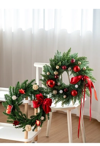 Detail of Christmas wreath with red bows, gold balls and green pine branches for decor