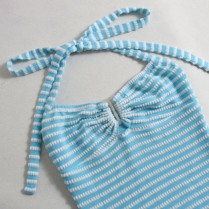 Dettaglio della chiusura a sbalzo e della trama a maglia a righe blu del vestito