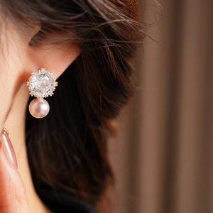 Close-up of elegant square flower stud earrings with purple pearl and cubic zirconia