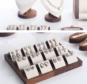 Macro detail of walnut wood and microfiber tiered jewelry stand for necklace and earring display