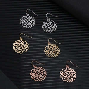 Three pairs of hollow metal earrings in silver, gold, and rose gold on a black background